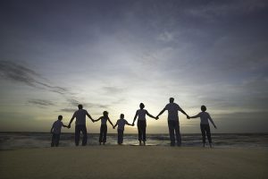 Famille se tenant la main sur la plage