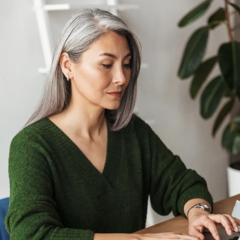 Photo d’une femme d’affaires aux cheveux gris concentrée tapant sur un ordinateur portable